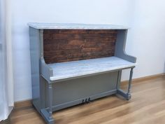 a gray bench sitting on top of a hard wood floor