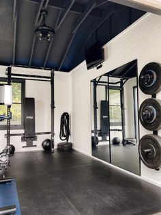 an empty gym room with mirrors and equipment