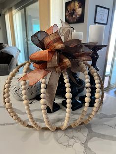 a wooden beaded wreath on top of a table with candles and pictures in the background