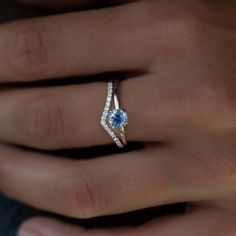 a woman's hand with a blue and white diamond ring