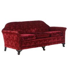 a red couch sitting on top of a white floor