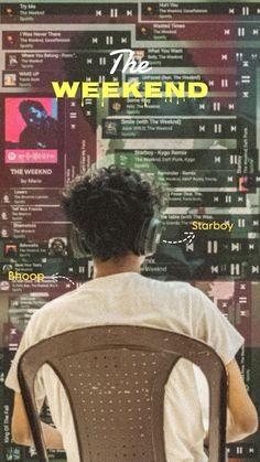 a man sitting in a chair with headphones on his ears looking at a poster