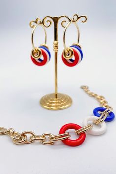 This Red, White, & Blue Gold Bracelet is the perfect accessory for adding some patriotic bling to your wardrobe! The chain alternates with circular rings with classic red, white, and blue tones, showing off a little bit of America's spirit in style. So throw it on and show your patriotic pride! Details:- Red, White, and Blue Colored Wings- Adjustable- Perfect 4th of July AccessoryDimensions:- 8.5" Resting Diameter- 1.25" Extension Trendy Red Circular Jewelry, Adjustable Red Chain Jewelry, Red Patriotic Jewelry For Party, Patriotic Red Jewelry For Party, Patriotic Blue Jewelry For Party, Blue Jewelry For 4th Of July Party, Red Jewelry For 4th Of July Party, Red Jewelry For Party On 4th Of July, Red Patriotic Bracelet Jewelry