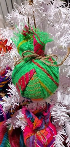 an ornament on top of a christmas tree decorated with ribbons and burlocks