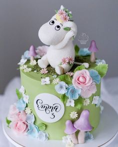 there is a cake decorated with flowers and a stuffed animal on top