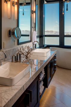 a bathroom with double sinks and large windows