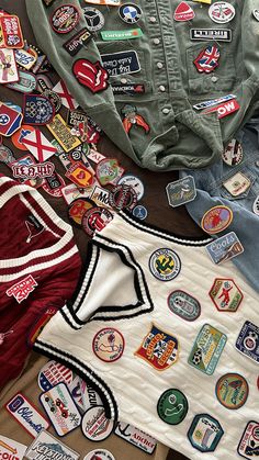 many different patches and badges are on the floor next to each other, including an army jacket