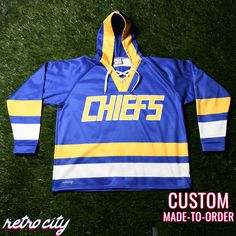 Charlestown Chiefs Slap Shot Custom Lace-Up Hockey Hoodie. Features:-Combines the fashion of a jersey with the performance of a hooded sweatshirt.-Constructed with our premium Vulcan Winterized fabric.-Inner polar fleece lining-Thick enough to keep you warm in cold temps, while being light and flexible enough to wear in supreme comfort.-Bottom adjustable drawcord-Lace-up collarColors:Royal, gold, white Free PersonalizationAdd your own name and number for free.*If you do not specify a custom name Hooded Team Spirit Tops With Logo, Team Spirit Long Sleeve Tops With Drawstring Hood, Hooded Tops With Team Logo, Team-colored Hooded Tops With Team Logo, Team-colored Long Sleeve Hoodie For Streetwear, Team-colored Hooded Top For Streetwear, Collegiate Hooded Top For Sports Events, Team-colored Long Sleeve Sports Hoodie, Team-colored Long Sleeve Hoodie Sportswear