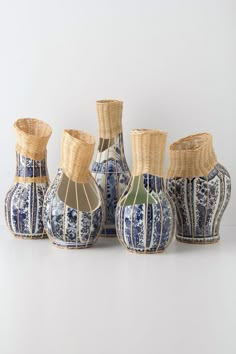 four blue and white vases sitting next to each other on top of a table