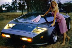 a woman leaning on the hood of a car