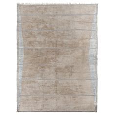 a beige rug with stripes and fringes on the bottom, in front of a white background