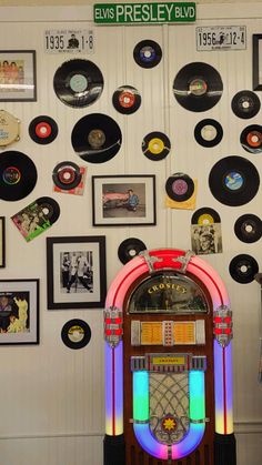 an old fashioned jukebox surrounded by records on the wall