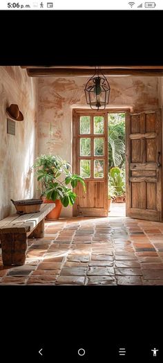 an open door leading into a room with potted plants on the floor and windows