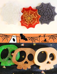 three halloween cookie cutters sitting next to each other on top of a black cloth