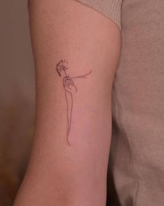 a woman's arm with a small flower tattoo on the left side of her arm