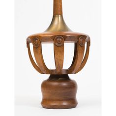 a wooden table with a metal vase on it's top and an iron base