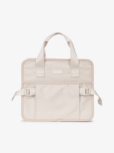 a white laptop bag with straps on the front and shoulder strap, sitting against a white background