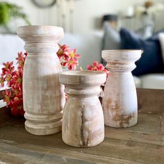 three white vases sitting on top of a wooden table