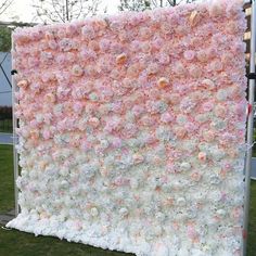 a large pink and white flowered wall in the grass