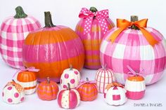 several pumpkins are decorated with pink and orange stripes, polka dots, and bows