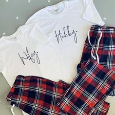 a white shirt and plaid pants with the words holiday written on it are sitting next to each other