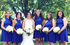 a bride and her bridesmaids pose for a photo in front of the trees