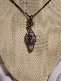 One of a kind amethyst Pendant in antiqued copper wire with a 5 mm amethyst bead.  The pendant is 2.25 inches in height and about half and inch wide. The pendant comes with an antiqued copper chain that is 7.25 inches in length.  (Note:There is a small hole in the back of one of the amethyst stones that is natural but became exposed from  the shaping and polishing of the stone. There wre currently 3 pendants available) According to several online claims, Amethyst is known to have several physica Artisan Amethyst Wire Wrapped Necklaces, Artisan Purple Wire Wrapped Jewelry, Artisan Purple Wire Wrapped Necklace, Unique Wire Wrapped Amethyst Necklaces, Unique Amethyst Wire Wrapped Necklaces, Artisan Amethyst Wire Wrapped Jewelry, Hand Forged Adjustable Purple Jewelry, Purple Amethyst Wire Wrapped Necklaces, Hand Forged Purple Pendant Necklace