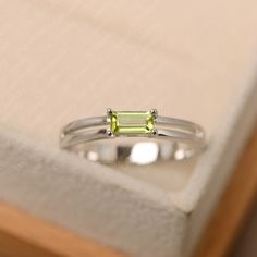 This ring features a 3*6 mm emerald cut peridot. Customization is available. It is made by hand, and it will take about 7 days to finish the ring after your payment is completed. Main stone: 3*6 mm emerald cut Main stone weight:0.00 ct Metal type: sterling silver /14k gold Accent stone: none Customization is available, just fee free to contact me, it is free to engrave inside the ring, it is free, you can leave a ntoe with your order, but it will be great no more than 15 letter. Any question, ju Peridot Engagement Rings, Original Engagement Rings, August Birthstone Ring, Ring Baguette, Green Sapphire Ring, Blue Gemstone Rings, Engagement Ring Photos, London Blue Topaz Ring, Silver Anniversary