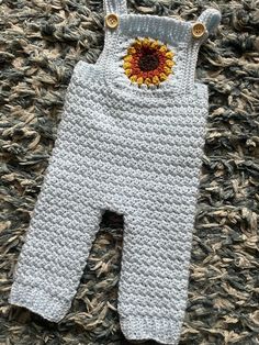 a crocheted baby's overall with a sunflower on it