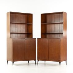 two wooden bookshelves sitting next to each other on top of a white floor