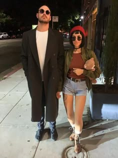 a man standing next to a woman on a sidewalk