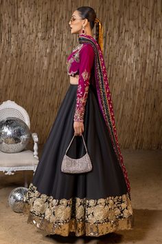 Raw Silk Black Lehenga Choli Pakistani Wedding Dresses are fully embellished with work of dabka, sequins, beads, and pearls on a long frock lehenga. It is worn over a beautiful plain silk lehenga and is paired with a Bright Pink Maisuri dupatta Purple Choli Lehenga: A black raw silk lehenga choli comes in a purple short choli with sequins, an embroidered border, and edging with a plum raw silk embellished choli and plum embellished and embroidered raw silk dupatta. Black Lehenga: Pakistani weddi Black Lehanga Ideas, Indian Wedding Outfits Black, Traditional Embroidered Lehenga, Black Anarkali For Wedding, Black And Pink Lehenga, Black Lehenga Outfit, Black Lehenga Party Wear, Purple Choli, Lehenga Choli Pakistani