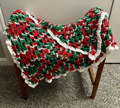 a crocheted blanket sitting on top of a wooden stool