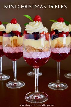 four glasses filled with dessert sitting on top of a table