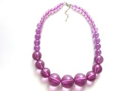 "Gorgeous lucite bead necklace in a lovely purple amethyst color.  All of the beads are completely translucent   The beads are graduated in size from the largest of one inch in diameter at the front to the smaller beads of 1/4\" inch around the back.  Necklace measures 51 centimeters or 20 inches plus a 2.5 inch extender chain. Lobster claw clasp, silvertone fittings.  Excellent condition." Back Necklace, Amethyst Color, One Inch, Purple Amethyst, Bead Necklace, Chain Styles, Lobster Claw, Necklace Lengths, 4 Inch