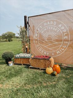 hay bales and pumpkins sit in front of a sign for the great hard apple ciderry