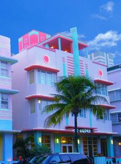 a pink and blue building with cars parked in front