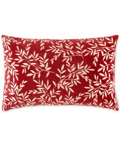 a red pillow with white leaves on it