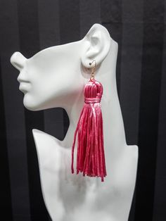 a white mannequin head with pink tassels on it