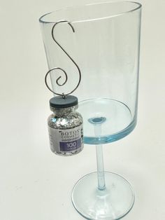 a glass with a metal handle next to a jar