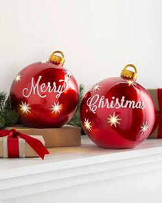 two red christmas ornaments sitting on top of a mantle