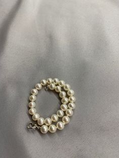 White Freshwater Pearl Bracelet. This bracelet features 28 White Freshwater Pearls AAA round to near round high luster 6.2mm with a heart clasp that is 18K white gold plate over 925 silver. The bracelet is 7 1/2 inches long measured laying flat. I hand knotted this bracelet using spectra thread. I use it instead of silk for my freshwater pearls. It does not stretch, hold oils, or break easily. It can also be gotten wet. I also like the heart clasp, they are easier to connect. We guarantee all of Silver Single Strand Pearl Bracelet, Elegant Pearl Bracelet With Lobster Clasp And Round Beads, White Single Strand Round Bracelet, White Round Single Strand Bracelet, White Single Strand Round Pearl Bracelet, Elegant White Pearl Bracelet With Lobster Clasp, White Single Strand Pearl Bracelet, Classic Single Strand Round Bracelet, Classic Round Sterling Silver Hypoallergenic Bracelet