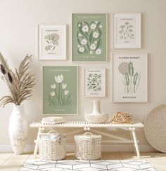 a white table topped with vases filled with flowers next to pictures on the wall