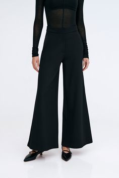 Claremont does all the legwork to keep your Monday-Sunday wardrobe polished. These relaxed wide-leg pants are fashioned from structured European ponte with a fly-front zipper and a wide waistband that rests comfortably at the mid-waist. Finished with functional pockets and a tuxedo panel to accentuate her clean lines. | Astrid, in black and in mist, is 5'9" (175 cm) tall, wearing size XS. Sejal, in black, is 5'8" (173 cm) tall, wearing size M. Approximately 39.5" (10.5 cm) from below the belt. Inseam is approximately 30" (76 cm). European Ponte, also known as Punto di Roma (60% Viscose, 30% Polyamide, 10% Lycra).Machine wash on delicate cycle, or hand wash in cold water. Tumble dry on low heat, or for best results, lay flat to dry. Designed in NYC. Handcrafted in Europe. | Marcella Claremo Sleek Tailored Wide Leg Pants, Wide-leg Culottes For Spring Evening, Tailored Versatile Wide Leg Pants, Spring Wide-leg Culottes For Evening, Tailored Sleek Wide Leg Pants For Spring, Spring Evening Wide-leg Culottes, Sleek Wide Leg Workwear Pants Full Length, Modern Wide-leg Evening Pants, Solid Color Evening Pants For Fall