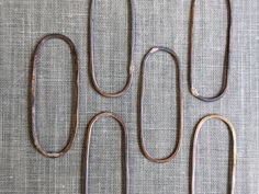 four pieces of metal sitting on top of a gray cloth covered table next to each other