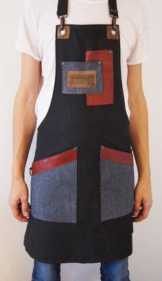 a man wearing an apron made out of denim and leather with red stitching on the front