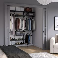 an open closet with clothes hanging on the shelves and shoes sitting on the floor in front of it