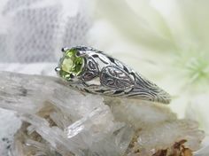 Natural Peridot Ring Etched Wedding Design#160 Made To Order Here we have a Victorian/Edwardian reproduction ring in sterling silver with a stunning natural peridot gemstone. This full cut round peridot gem is 6mm in diameter. The inside of the band is marked 925 for sterling. Notice the beautiful floral design of the silver filigree setting and band. This is a lovely rendition of an Antique filigree ring; and it is ready to wear. A gift ring box is included and all rings are shipped in the box Antique May Birthstone Rings For Wedding, Antique May Birthstone Wedding Rings, Green Peridot Jewelry For Wedding, Ornate Birthstone Jewelry For Weddings, Green Engraved Wedding Rings, Wedding Ring With Hallmarked Peridot, Green Peridot Wedding Rings, Antique Green Jewelry For Wedding, Ornate Green Wedding Ring