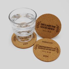 three wine cork coasters sitting next to a glass filled with water on top of a white surface