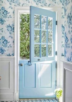 a blue front door in a white and blue wallpapered room